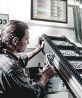 Technician examining sockets on conveyor, related to Zyklop 8790 HMB Three Eighths Inch Drive Socket With Ball Intercept Ring for manual and machine work.