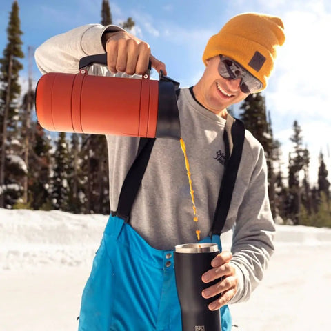 Insulated French Press Keeps Your Daily Joe Hella Hot For Hours With Tough Stainless Steel Build And Secure Twist Lid Crafted For Cabin Weeks And Backyard Chillin 32 Fl Oz Red Rock pouring into a cup in snowy outdoors.