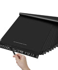 Hand holding Black 14.5x19 Inch Poly Mailers, 50 Pack, Heavy Duty Self Adhesive Bags With Tear Strip For Clothes.