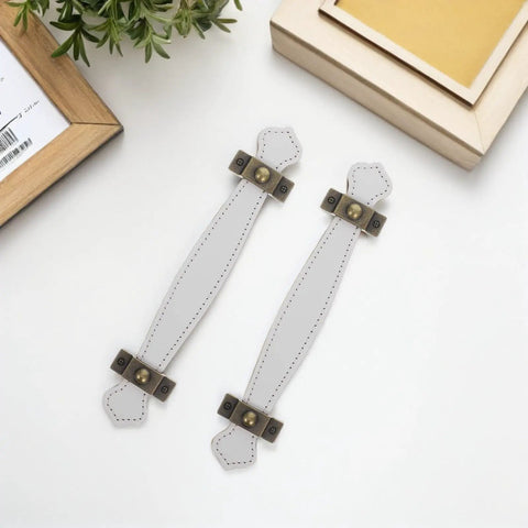 Overhead view of 2 Slick Vintage Zinc Alloy Cabinet Pulls with White PU Leather Grip on white surface