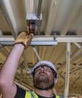 Man using Magnetic Pocket Laser Level With 360 Degree Wall Attachment, Red Laser Line Reaches 30 Feet, 3 Bubble Vials for ceiling alignment.