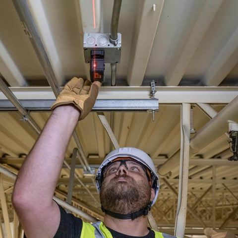 Man using Magnetic Pocket Laser Level With 360 Degree Wall Attachment, Red Laser Line Reaches 30 Feet, 3 Bubble Vials for ceiling alignment.