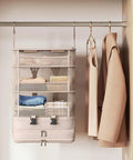 Heavy Duty Hanging Travel Shelf Bag Organizer For Luggage Suitcase With Ventilated Mesh Pockets And Water Repellent Nylon Fabric, hanging on a closet rod.