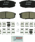Bosch BC1304 QuietCast rear ceramic brake pad set with mounting hardware and grease packet.