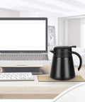 Monster 68 Ounce Stainless Steel Vacuum Insulated Coffee Carafe with Double Wall Construction on office desk near laptop