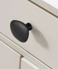 Legit Premium Matte Black Pebble Cabinet Knobs For Dresser Drawers In A Solid Ten Pack with 1.38-inch shape on a drawer.