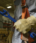 Worker holding Dual Size Lineman's Wrench With Small Openings Five Eighths And Thirteen Sixteenths Inches And Large Openings Twenty Nine Thirty Second And One Three Thirty Second Inches Forged Bar Steel Heat Treated For Longevity Made In USA in warehouse