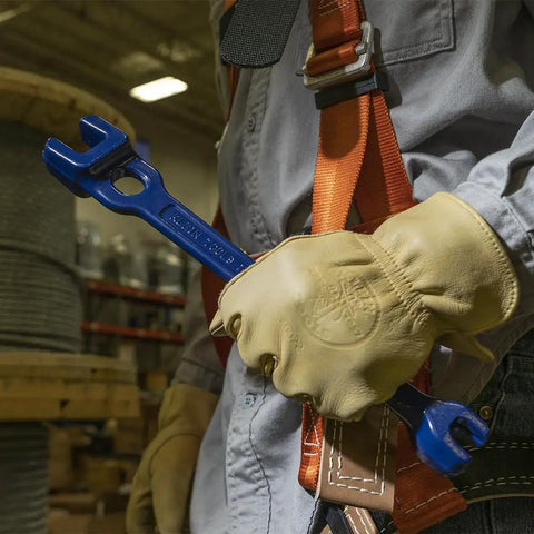 Worker holding Dual Size Lineman's Wrench With Small Openings Five Eighths And Thirteen Sixteenths Inches And Large Openings Twenty Nine Thirty Second And One Three Thirty Second Inches Forged Bar Steel Heat Treated For Longevity Made In USA in warehouse