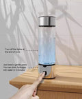 Portable Hydrogen Water Bottle With 1400ppb Generator, 460ml Hydration Cup shown on wooden table with finger pressing button