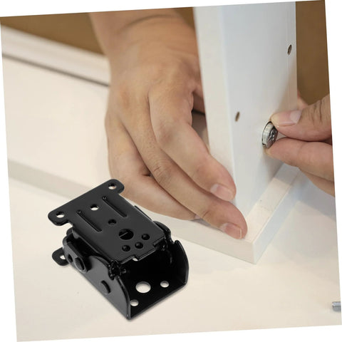 Hand installing space-saving folding hinge set on furniture.