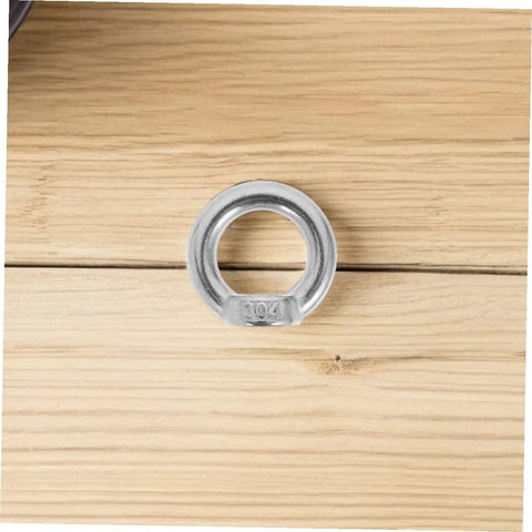 Close-up of M8 304 stainless steel lifting eye nut on wooden surface, part of 8 Pack M8 304 Stainless Steel Lifting Eye Nuts Heavy Duty Threaded Rigging Hardware With No Fuss Setup For Marine Hoisting And Industrial Job Site Work Built Tough.