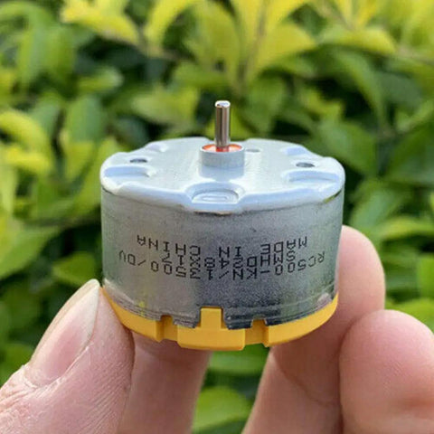 Close-up of RC500-KN Mini 32mm Round Spindle Motor held in hand, showcasing DC 6V 12V, 5300 RPM for robots, vacuums, and DIY projects.