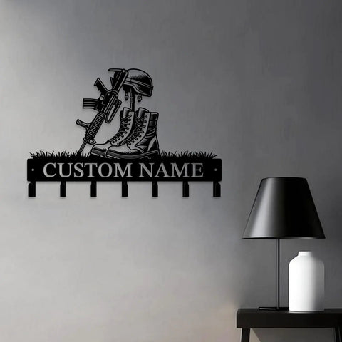 Matte black cast iron personalized gun theme wall hooks for keys and clothes with custom name engraving in a man cave setting.