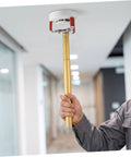No Sweat Premium Smoke Sensor Removal Tool With Heavy Duty Claw Head Aluminum Body Ladder Free Ceiling Detector Puller in use to retrieve smoke alarm.