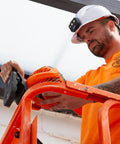 Worker installing Cordless Rechargeable Fan With USB-C Charging Cord And Multiple Mounting Options For The Jobsite on a ladder