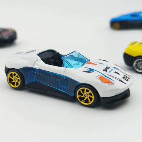 White diecast car with 10 Pack 1/64 Diecast Car Wheels And Tires Set With Mixed Rubber Tires For Custom 1/64 Models, close-up view