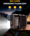 Portable Jump Starter With Air Compressor 6000A Peak 12V Jump Box 160 PSI Tire Inflator LED Display shining on campsite table