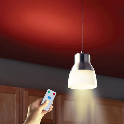 Person holding remote near hanging light, using Go To Rechargeable LED Light Bulbs With Remote Control Cordless Warm White Emergency Lamp.