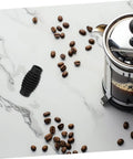 Heat Insulation Pad Rubber Sleeve For Espresso Steam Wand Burn Protection next to coffee beans and French press on marble surface