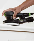 Hand using Topshelf Random Orbit Sander With Stepless Speed Control on wood surface for smooth finishing.
