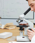 Scientist using microscope with Pro Grade 0.01mm Microscope Calibration Slide Ruler With Stage Micrometer Glass Reticle Ruler Dual Scale nearby