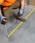 Person using 9235 Heavy Duty Magnetic Tape Measure With 16 Foot Reach, Double Hook, Double Sided Nylon Reinforced Blade on floor