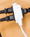 Three Outlet Extension Cord 15 Ft Power Strip 2 Pack White UL Listed with cables plugged on wooden surface