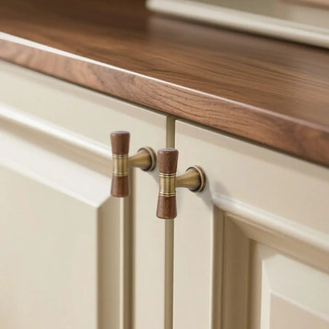 Close-up of Six Pack Antique Brass Walnut Cabinet Pulls And Knobs Set on cream kitchen cabinets, 3.78 Inch Hole Center