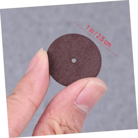Close-up of a small disc from the 36 Piece Grinding Wheel And Cutting Disc Set For Metalworking Tools, held between fingers.