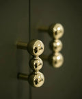 Heavy Duty Solid Brass Cabinet Knob With A Slick Single Hole Design And Top Shelf Modern Hardware Upgrade For Kitchens Cupboards Wardrobes And Bedroom Furniture close-up view of polished brass knobs on cabinetry.