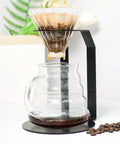 Kick Your Morning Routine Upstairs With This Rock Solid Iron Brew Station Perfect For Home Baristas Seeking Consistent Heat And A Go To Pour Over Setup Always On Point - Iron pour over stand with glass dripper and coffee pot.