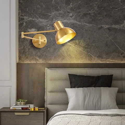 Industrial Metal Swing Arm Wall Sconce With A Sleek Dome Shade And Knockout Build For Cozy Bedroom Or Living Room Reading Vibes E27 Socket Modern Wall Fixture Black Brass Finish with golden finish light mounted over a bed.