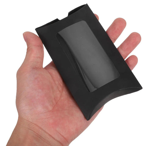 Hand holding a single black kraft paper pillow gift box with window, part of 50 Pack Black Kraft Paper Pillow Gift Boxes With Window For Birthday Parties And Events