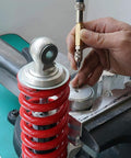 NICECNC nitrogen needle kit with needle head used on a red coilover shock, hand guiding the needle.