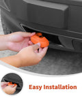 Person installing orange Tow Hook Covers For Ford Bronco Sport And Maverick FX4 Off-Road Tremor on front bumper