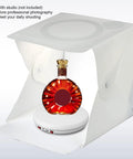 Stunning 25 Cm Electric Rotating Display Stand With Led Light showcasing a bottle inside a photography tent on a motorized base.