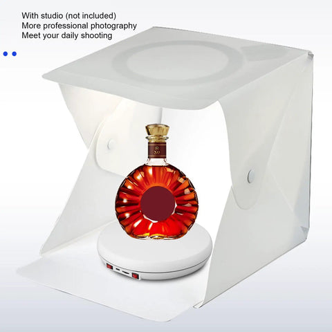 Stunning 25 Cm Electric Rotating Display Stand With Led Light showcasing a bottle inside a photography tent on a motorized base.