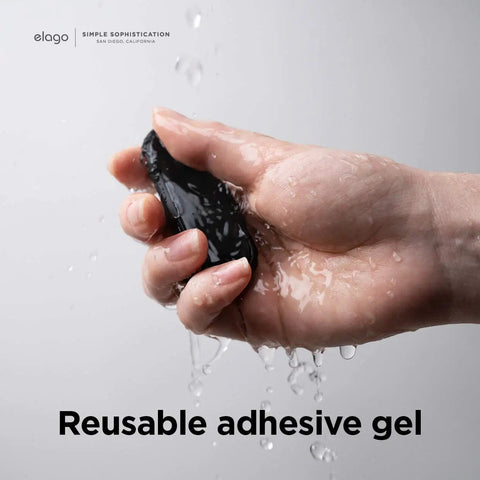 Hand holding a black reusable adhesive gel for Magnetic Cable Management Buttons And Holder To Keep Three Cables Neat And Tidy