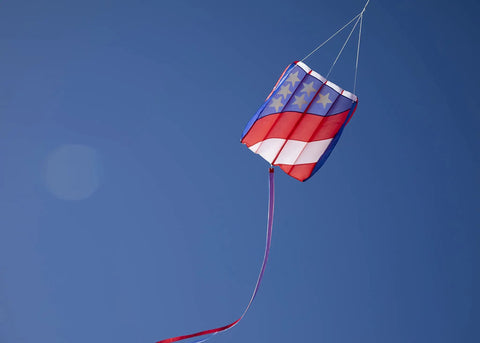 Patriot Wave 7.5 Parafoil Kite flying in blue sky, single line, 28in W x 36in H, lightweight ripstop polyester, red tail visible