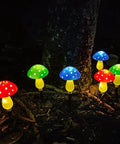 Mushroom Solar Lights for Outdoors Pack of 6 LED Garden Stake Decor glowing in various colors at night.
