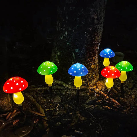 Mushroom Solar Lights for Outdoors Pack of 6 LED Garden Stake Decor glowing in various colors at night.