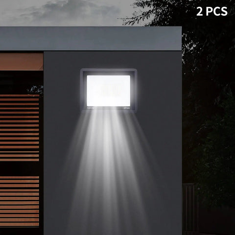 LED Work Light 100W 8000LM Flood Light Outdoor IP66 Weatherproof Plug in mounted on a wall, illuminating with broad beam.
