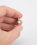 Close-up of hand holding a spark plug from Mini Metal Nitro Engine Starter Kit For L2 Nitro Engine Model And Physics Experiments.