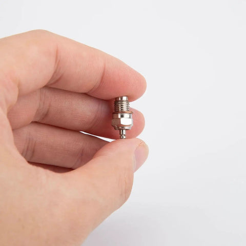 Close-up of hand holding a spark plug from Mini Metal Nitro Engine Starter Kit For L2 Nitro Engine Model And Physics Experiments.