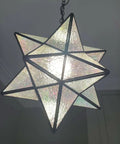 Moravian Star Tiffany Style Stained Glass Ceiling Pendant Lamp with 12 Inch Lampshade and 51 Inch tall iridescent glass glowing.