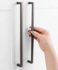 Hand reaching for Oil Rubbed Bronze 10 Inch Square Bar Cabinet Pull Handle With 10 Inch Hole Centers Zinc Alloy Smooth Curved Back