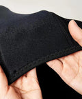 Hands holding flexible neoprene fabric of Lightweight Neoprene Wake Surf Vest For Men, showing stretchability and stitching.