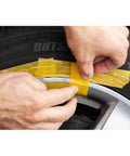 Applying tape to a black alloy wheel before using the Solid Alloy Wheel Repair Kit For Black Rims Smooths Out Curb Rash And Road Scuffs DIY.