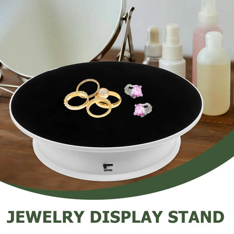 Spinning 360 Electric Turntable With Adjustable Dual Speeds For Jewelry Watch Showcase And Photography Shots Using Sleek Plastic Base displaying rings and earrings.