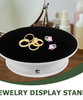 Stylish Electric Rotating Display Turntable For Jewelry Photography And Retail Store Use With Adjustable Speed Motorized Platform and Anti-Skid Base showcasing rings and earrings on a black velvet surface.